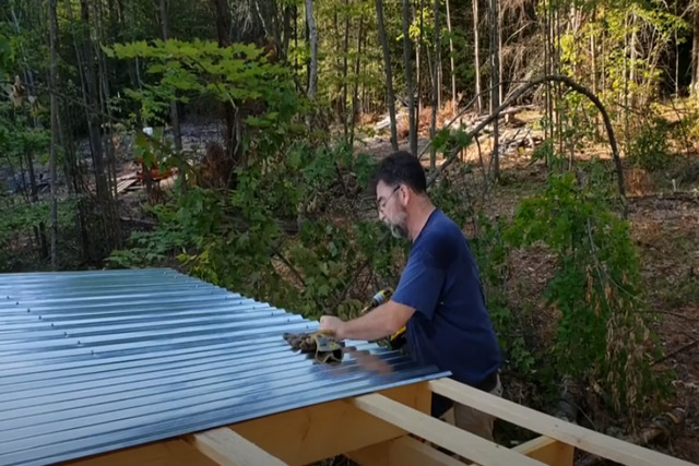 Roofing workers installing corrugated metal roof